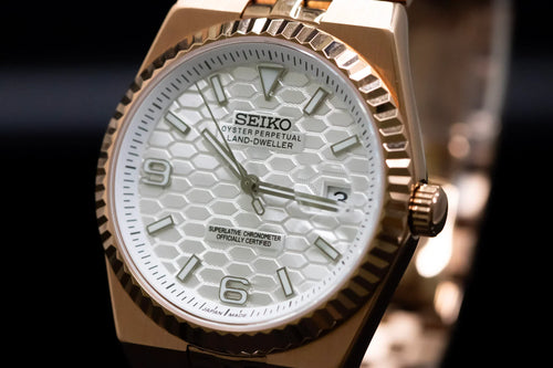 ORA Vanguard 36 rose gold plated white honeycomb dial watch, fluted bezel – front view on reflective surface