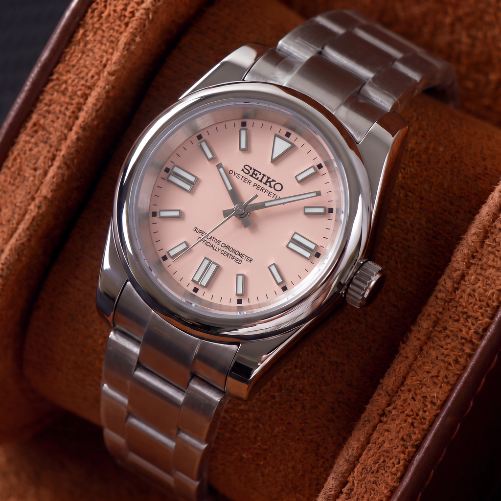 ORA Classic Sport-Style 36mm Seiko Mod watch, blush pink dial, smooth polished bezel, steel three-link bracelet – resting in a suede-lined watch box