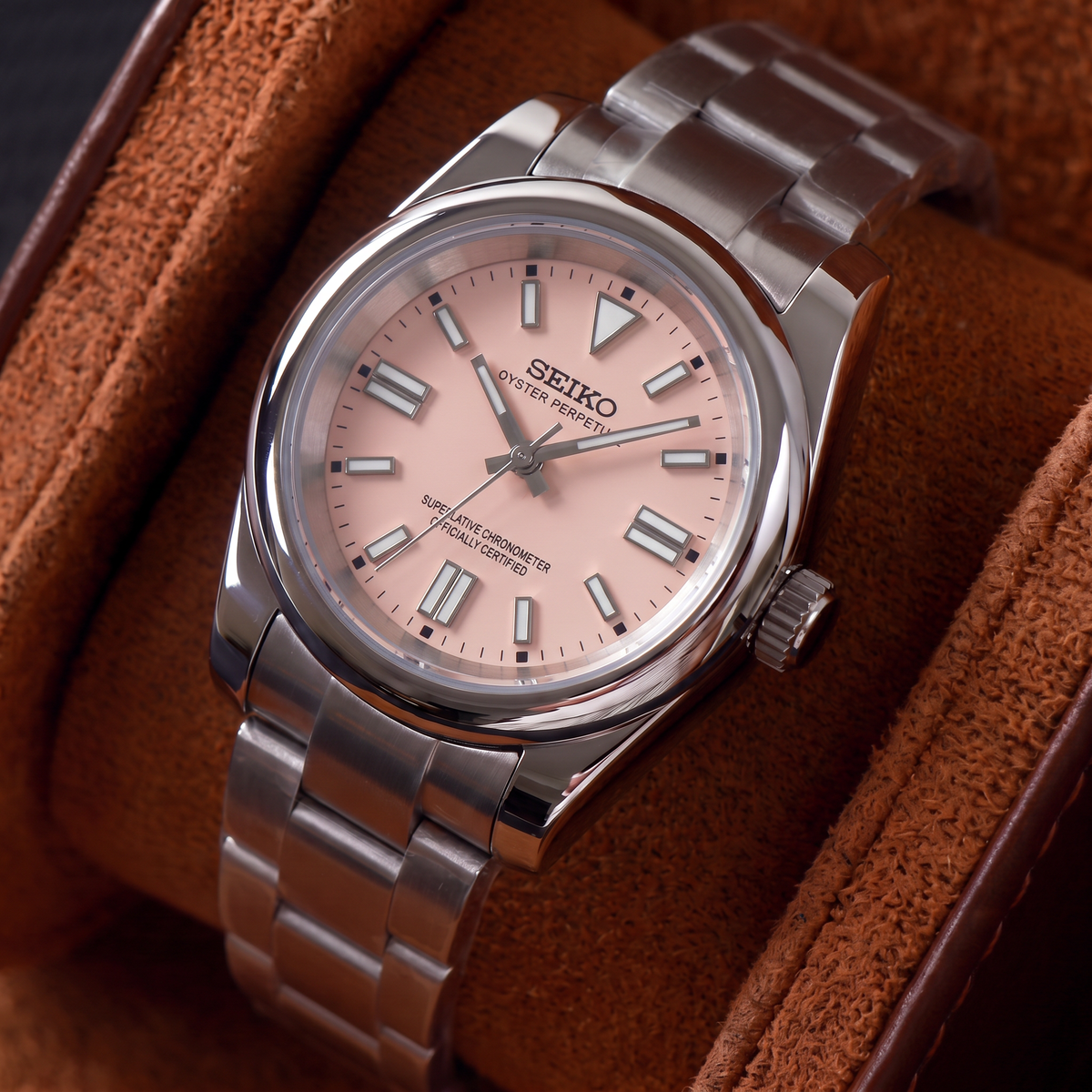ORA Classic Sport-Style 36mm Seiko Mod watch, blush pink dial, smooth polished bezel, steel three-link bracelet – resting in a suede-lined watch box